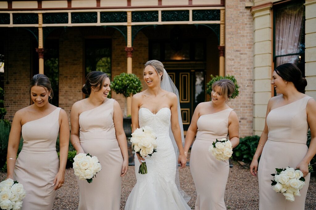 bride and bridesmaids with white rose flower bouquets