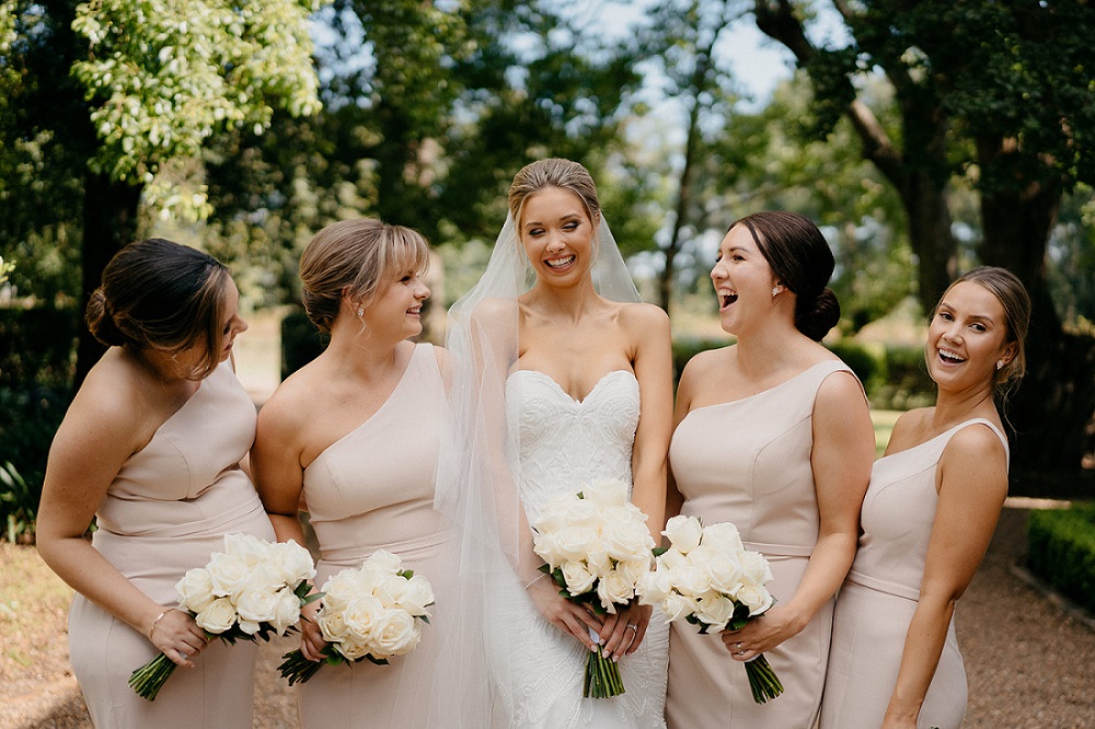 bride and bridesmaids with white rose bouquets